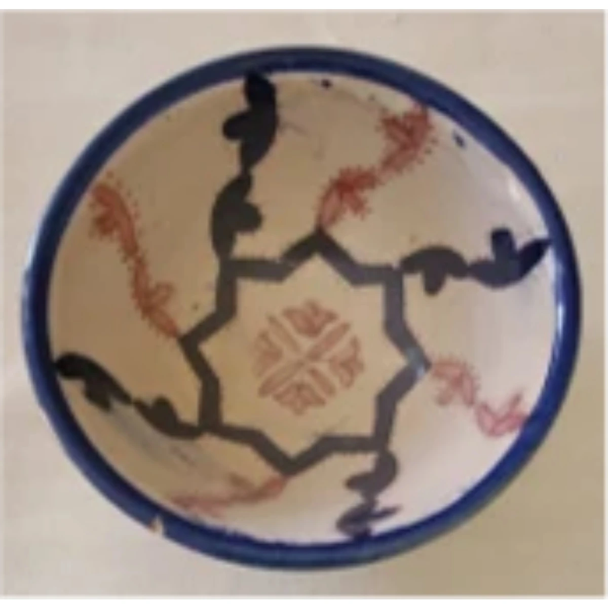 A multicolored ceramic bowl decorated with an octagonal star motif.