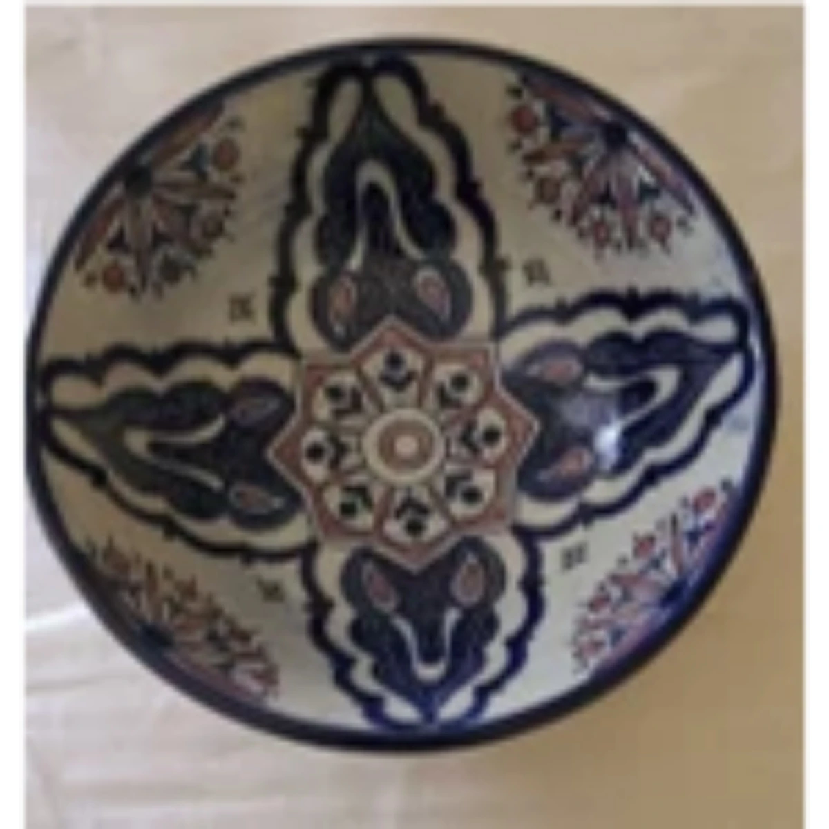 A multi-colored ceramic bowl featuring a floral and geometric design.